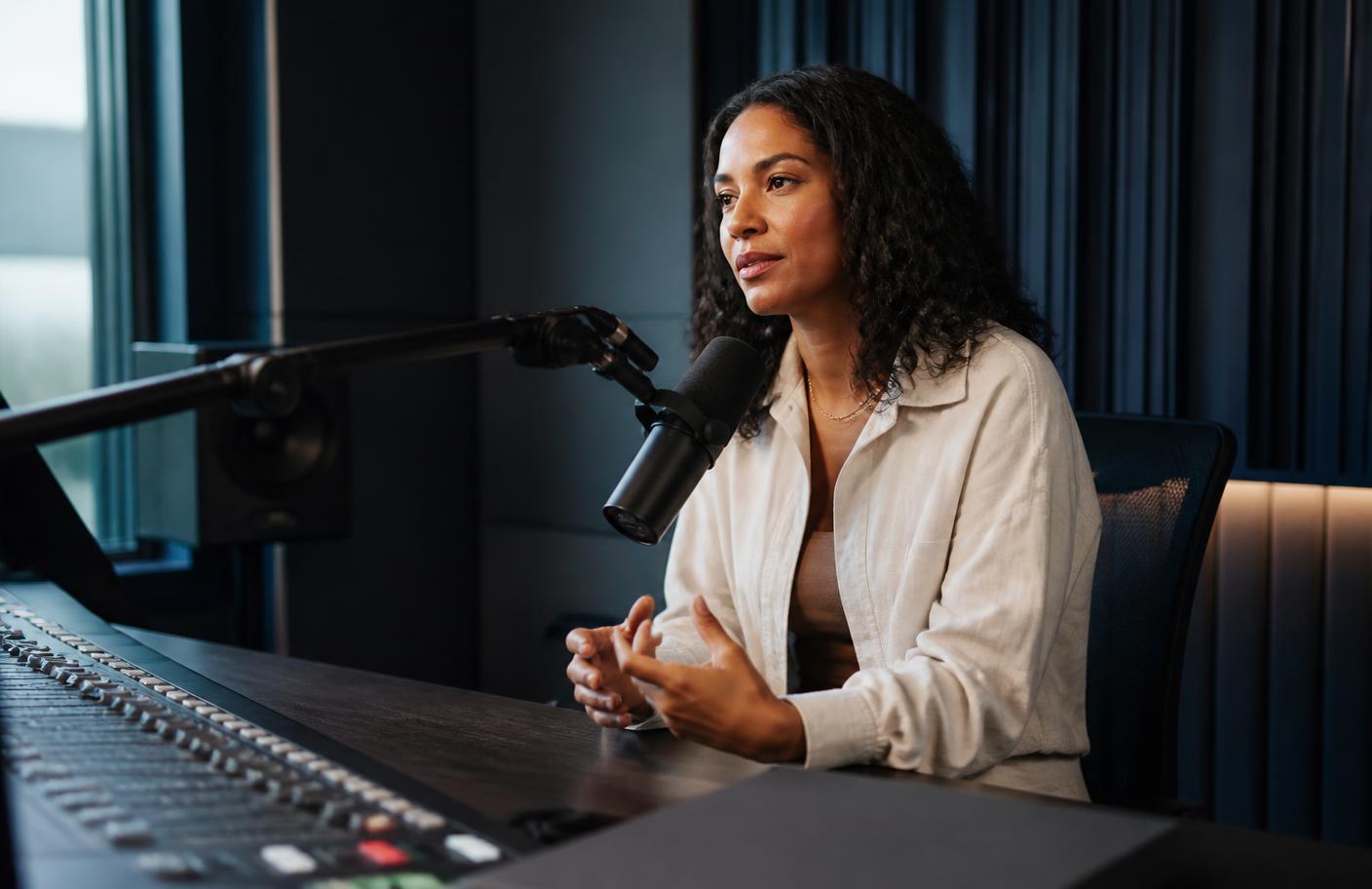 Podcast host speaking into a microphone in a professional studio
